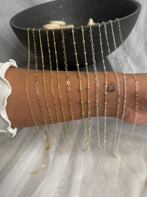 Gold and silver chains draped across a forearm